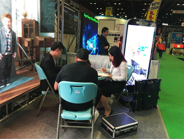 奥兰多橘城会展中心ROYAL皇家88展位现场，外贸部经理黄勇强和何巧玲与意向客户在交谈中